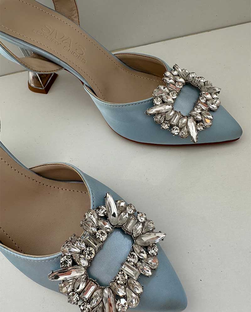 Όμορφο γαλάζιο σατέν mule με ιδιαίτερο διάφανο τακούνι και διαμαντένια αγκράφα μπροστά, ιδανικό για γάμους, βαπτίσεις, events, αλλά και βραδινές εξόδους.