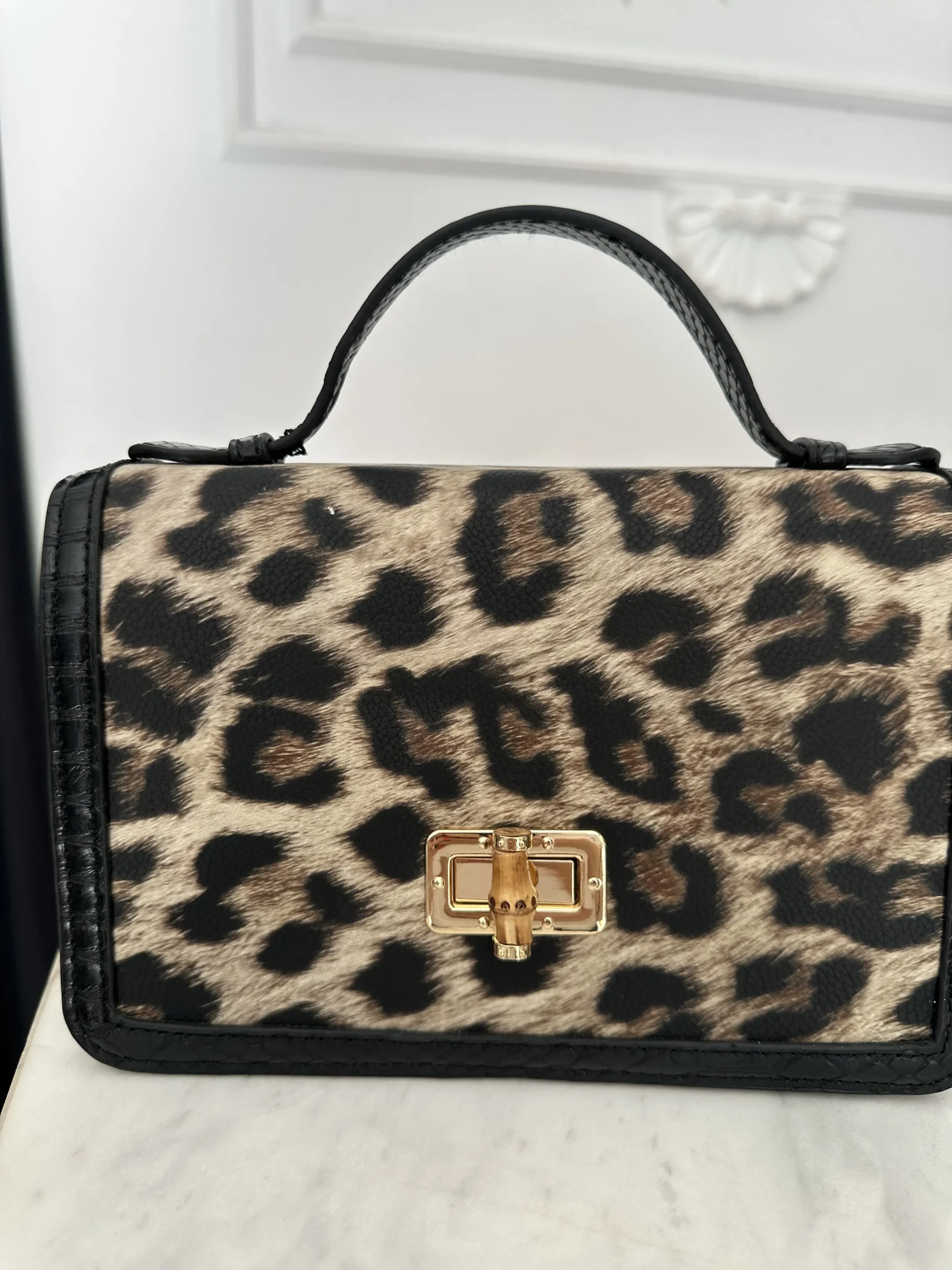 Εντυπωσιακή λεοπάρ τσάντα από οικολογικό δέρμα χειρός ή χιαστί με λουράκι . Διαθέτει μία θήκη αποθήκευσης με χρυσό κλείδωμα και ξύλινη λεπτομέρεια.
