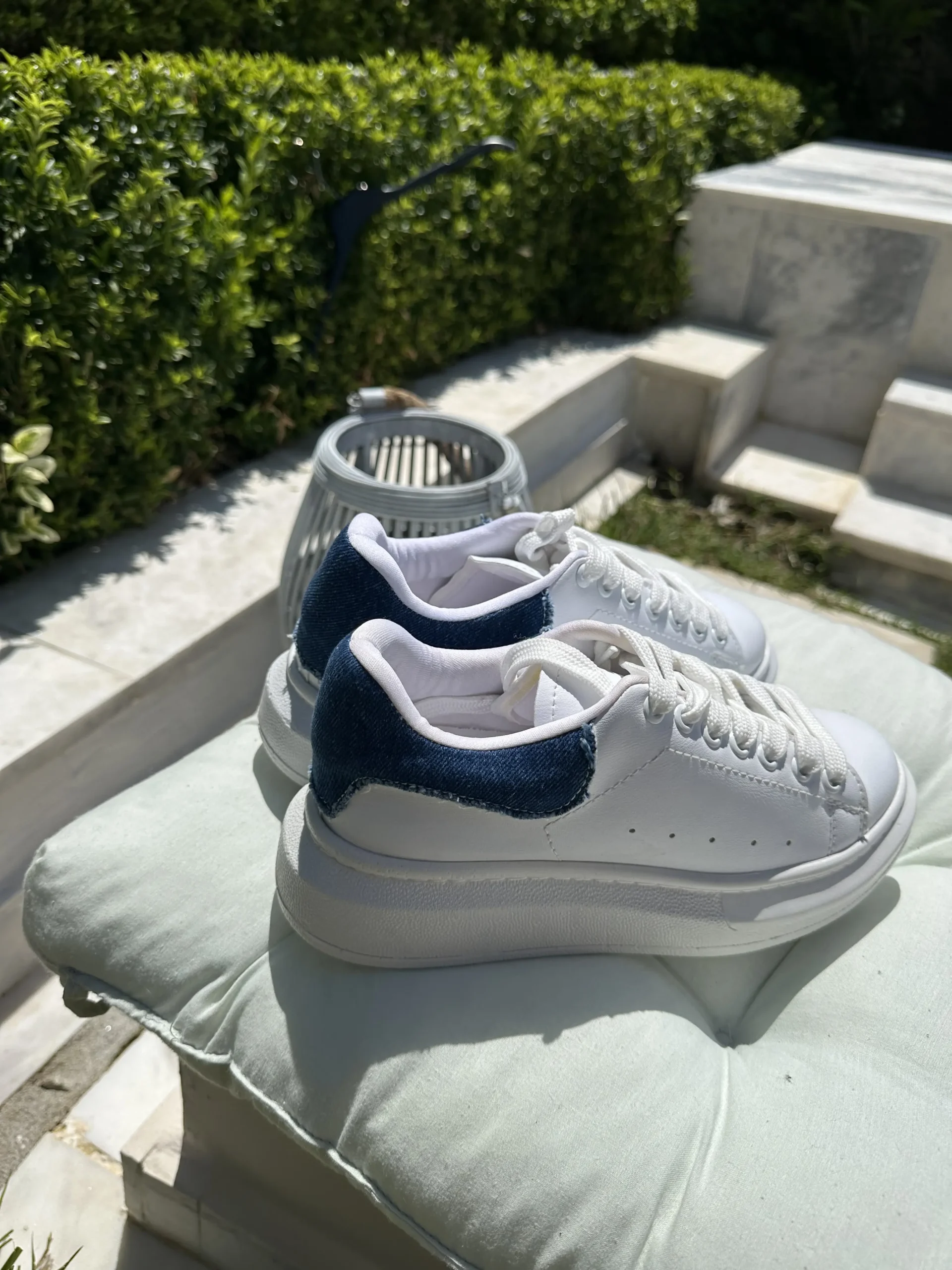 Λευκά αθλητικά με κορδόνια και λεπτομέρεια τζίν στο πίσω μέρος.