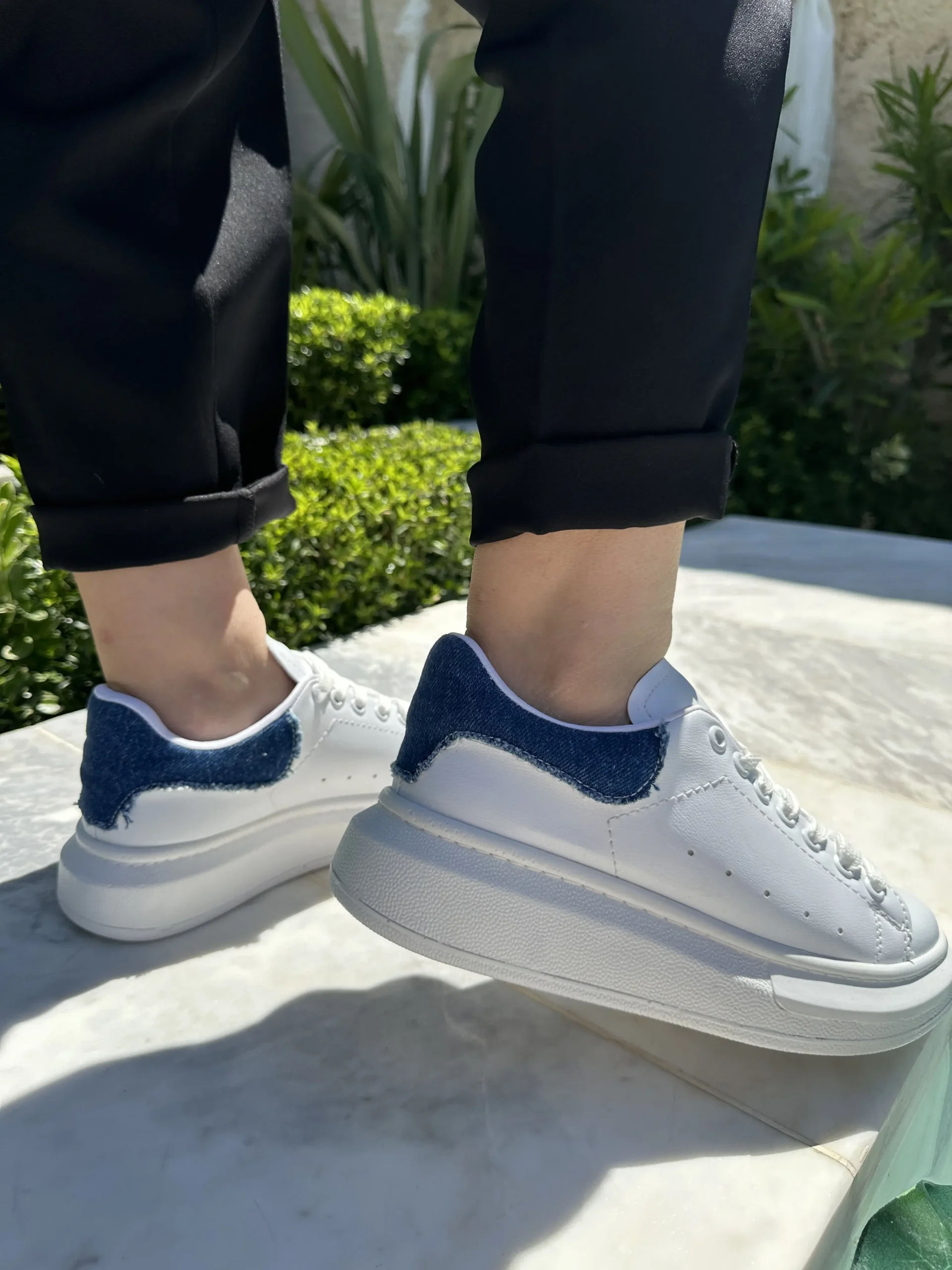 Λευκά αθλητικά με κορδόνια και λεπτομέρεια τζίν στο πίσω μέρος.