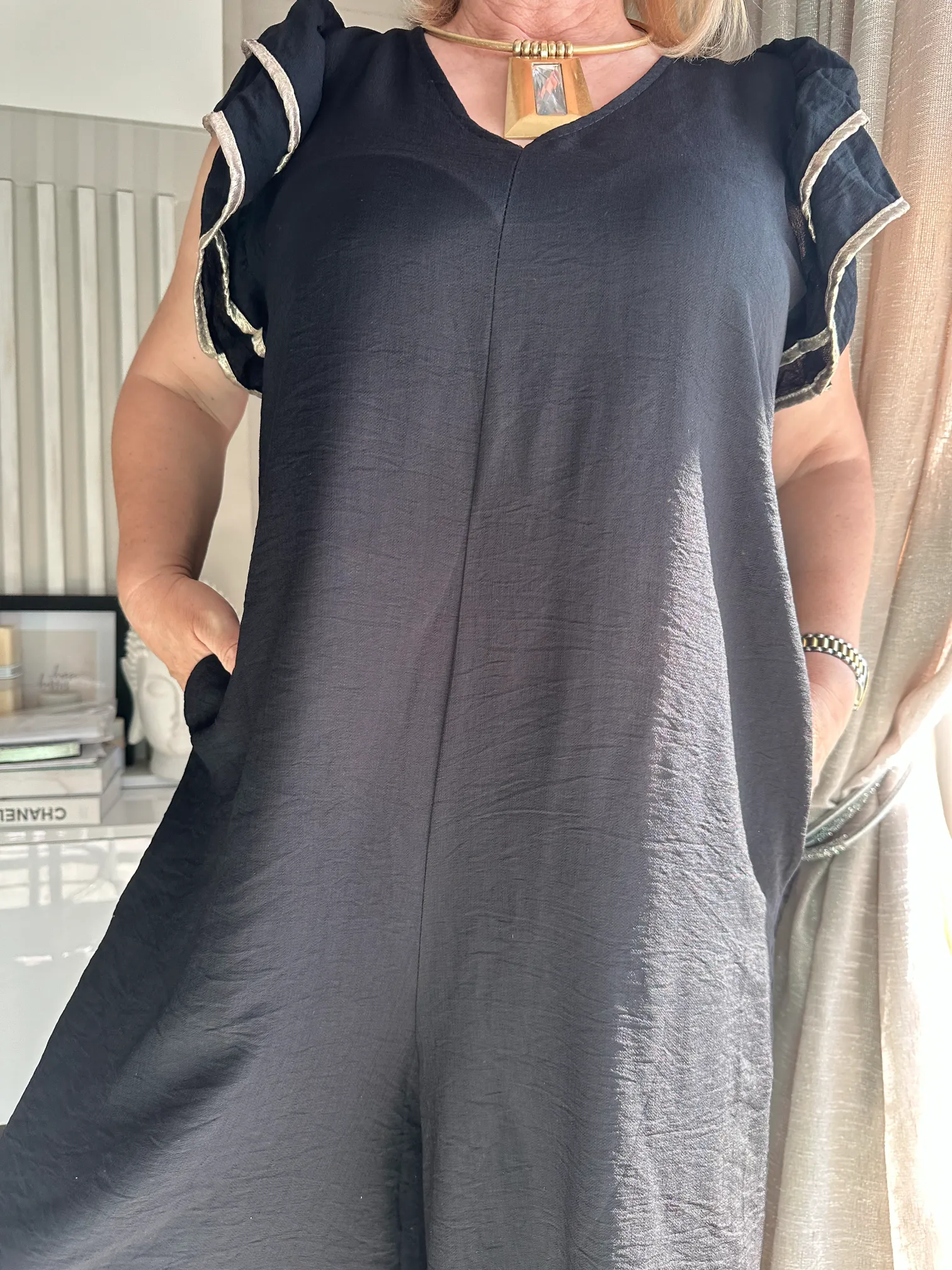 μαύρη ολόσωμη φόρμα με βολάν στα μανίκια