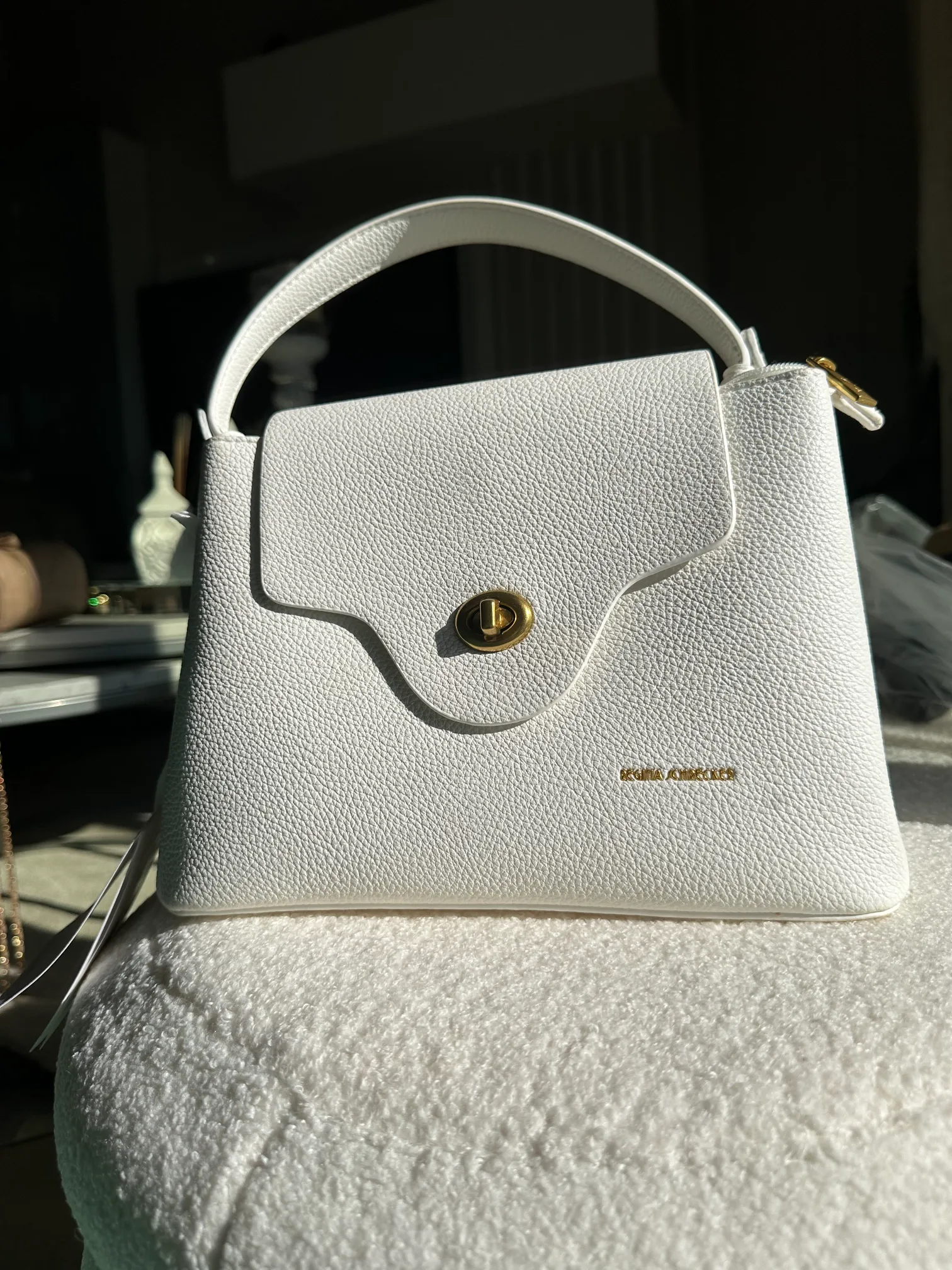 λευκή τσάντα με χερούλι και χρυσή λεπτομέρεια